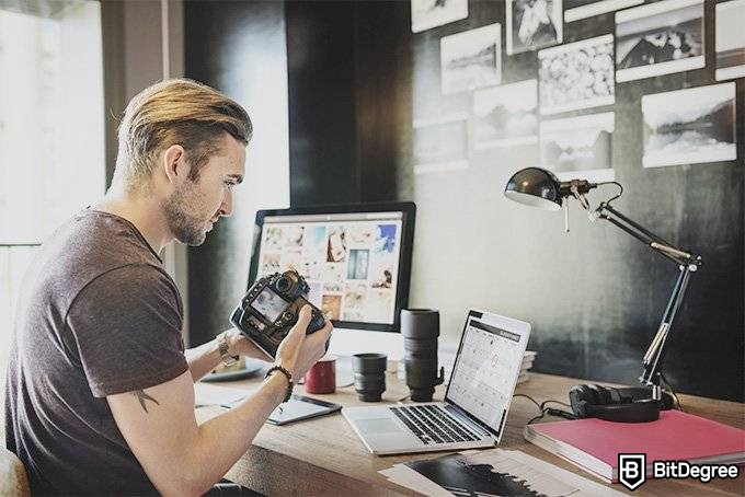 Mejores Cursos Alison: Fotógrafo observando una computadora.